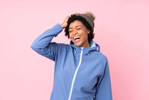 Mujer morena con sombrero de invierno sobre fondo azul aislado