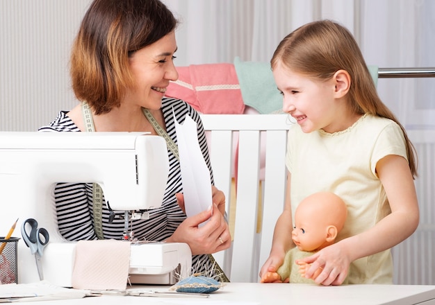 Mujer mostrando al niño cómo coser en casa