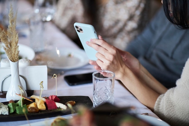 Mujer mostrando algunas fotos de su teléfono inteligente a sus amigos