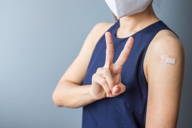 mujer mostrando el brazo después de recibir la vacuna covid 19