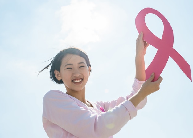 Mujer mostrando cinta rosa para apoyar el cáncer de mama.