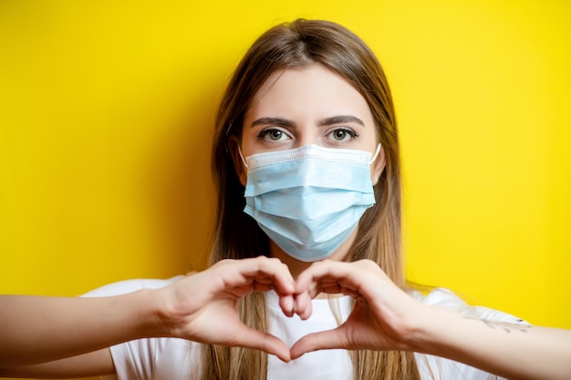 mujer mostrando forma de corazón con máscara