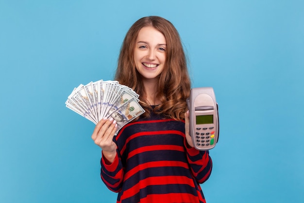 Mujer mostrando gran fan de los billetes de dólares y terminal de pago pos mirando a la cámara con una sonrisa