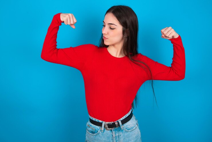 Foto mujer mostrando los músculos de los brazos sonriendo orgulloso concepto de fitness