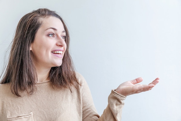 Mujer mostrando la palma de la mano abierta sobre fondo blanco.