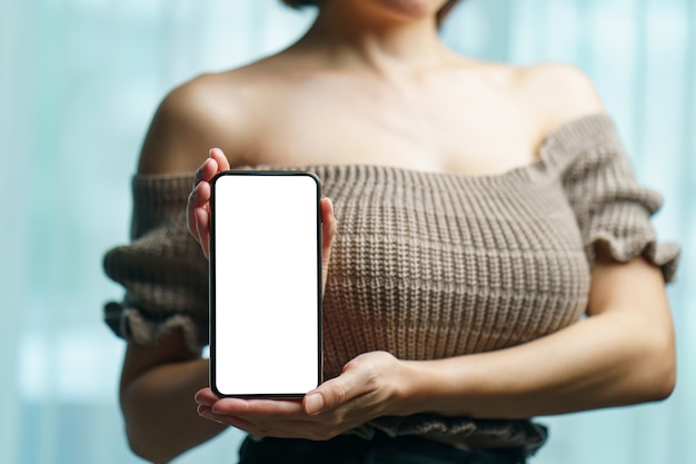 Foto mujer mostrando pantalla en blanco blanco en teléfono móvil