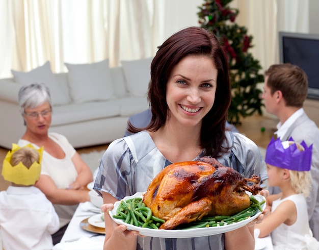 Mujer mostrando pavo de Navidad para la cena familiar