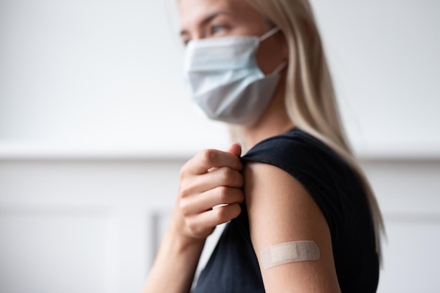 Mujer mostrando su brazo con vendaje después de recibir la vacuna