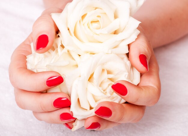 Foto mujer mostrando sus hermosas uñas con manicura y rosas