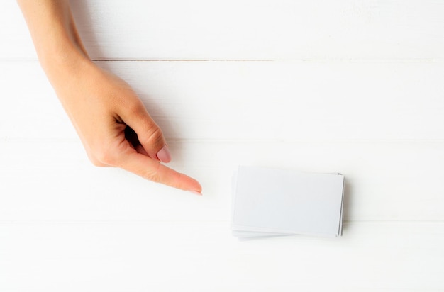 Mujer mostrando en una tarjeta de visita blanca en tamplate de manos para su diseño