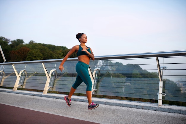 Mujer motivada Mujer afroamericana que se siente motivada mientras corre por la mañana