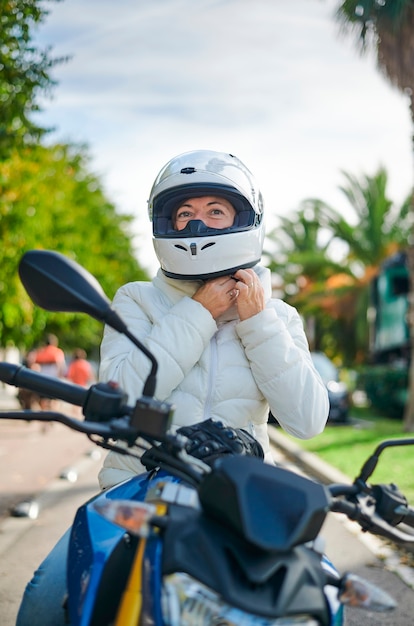 Mujer motociclista ajustando su casco