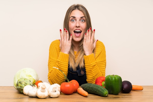 Mujer con muchas verduras con expresión facial sorpresa