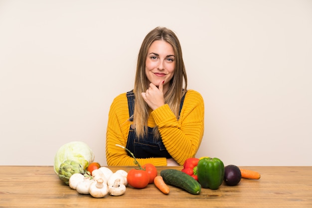 Mujer con muchas verduras riendo