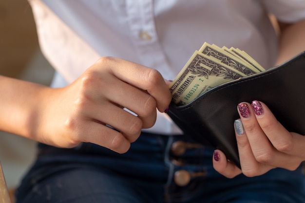 mujer con mucho dinero en la billetera