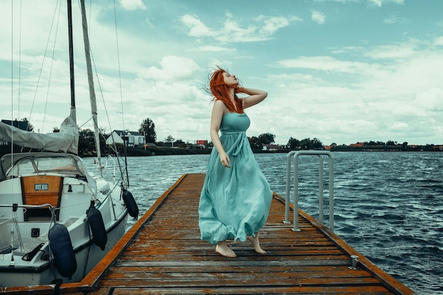 mujer en el muelle con el telón de fondo de barcos y yates