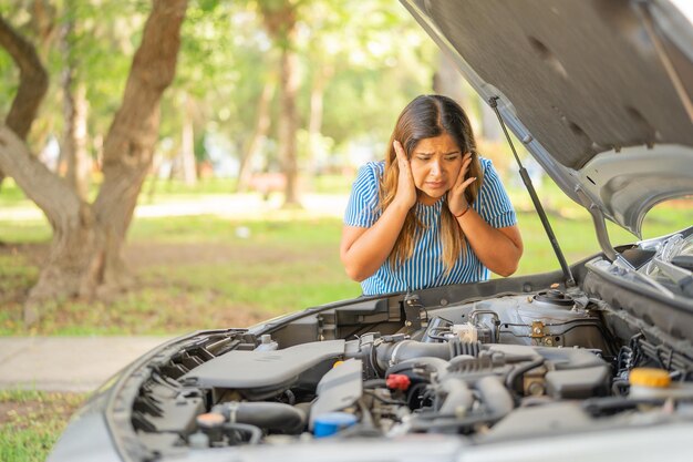 Foto mujer muestra impotencia al ver que el motor de su auto no funciona