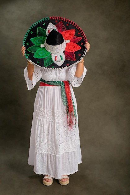 Mujer muestra sombrero mexicano con los colores de la bandera mexicana Ropa típica y sombrero de mariachi