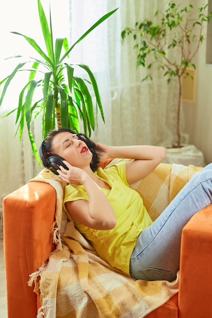 Mujer mujer en auriculares con los ojos cerrados escuchando música podcast