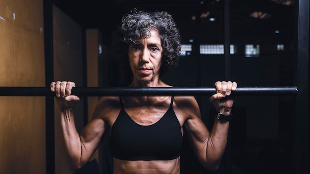 Mujer musculosa madura haciendo un pullup