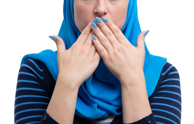 Mujer musulmana árabe cubriendo su boca aislada sobre fondo blanco