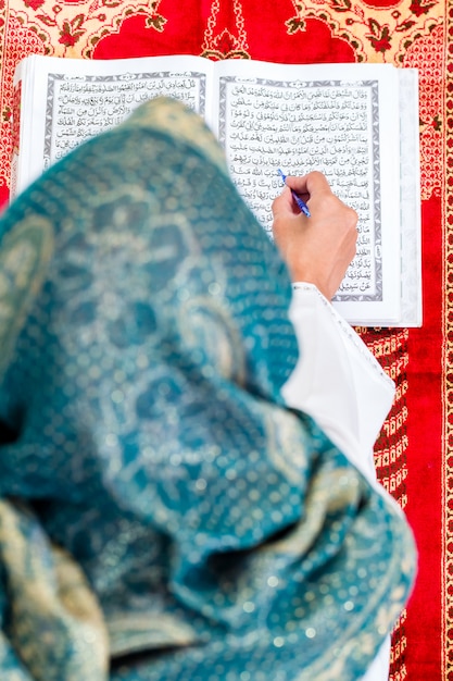Mujer musulmana asiática estudiando Corán o Corán
