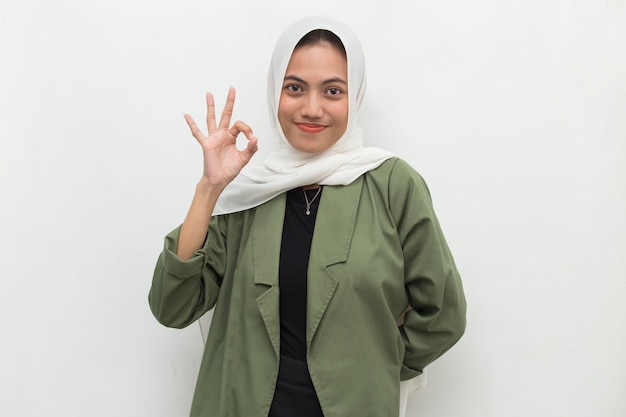 Mujer musulmana asiática con hijab con gesto de signo ok