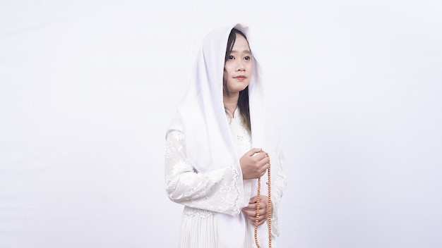 Mujer musulmana asiática con rosarios rezar con tasbih en blanco