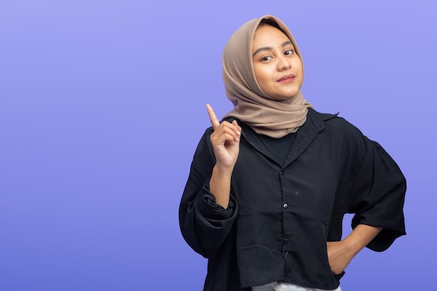 Mujer musulmana asiática sonriendo mientras levanta el gesto de la mano encontrando una idea con espacio