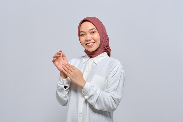 Mujer musulmana asiática sonriente aplaudiendo celebrando el éxito con expresiones faciales felices aisladas sobre fondo blanco