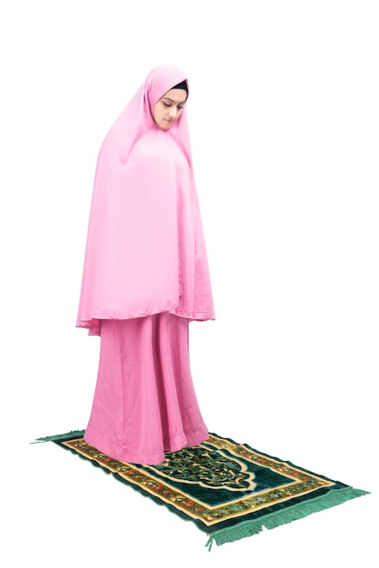 Mujer musulmana asiática con velo en posición de oración (salat) aislada sobre fondo blanco