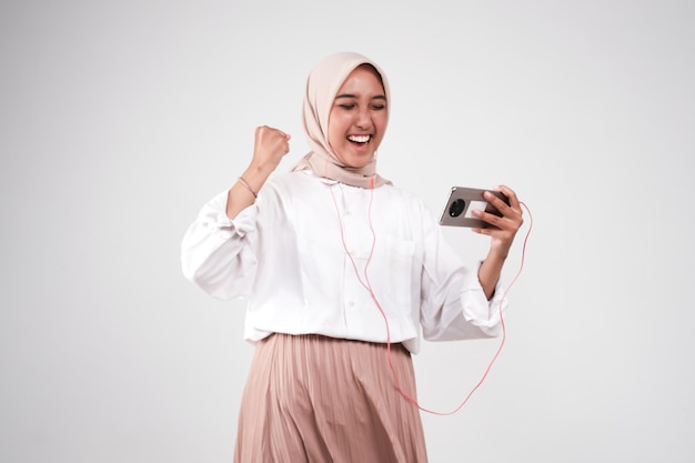 Foto una mujer musulmana con auriculares y escuchando música con sus auriculares