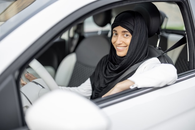 Mujer musulmana conduce un coche