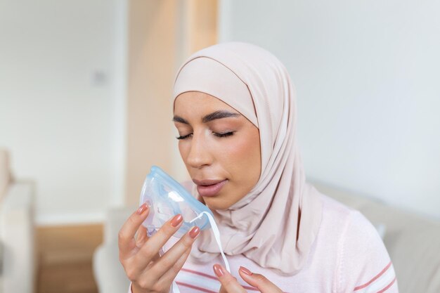 Foto mujer musulmana enferma haciendo medicina de inhalación es la mejor medicina mujer enferma usando una máscara de oxígeno y sometida a tratamiento para covid-19 mujer con un inhalador