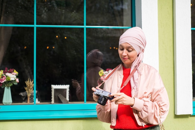 Mujer musulmana está haciendo fotos por teléfono móvil afuera