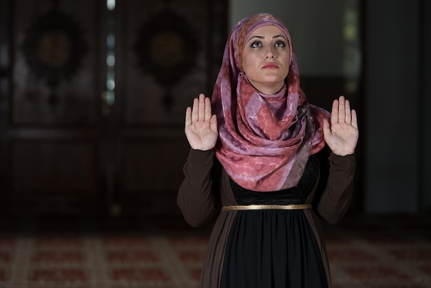 Mujer musulmana está rezando en la mezquita