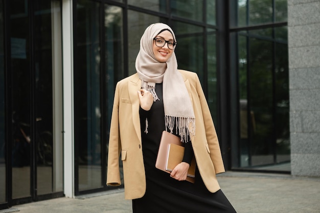 Mujer musulmana con estilo moderno en hijab en la calle de la ciudad