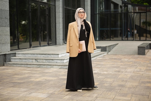 Foto mujer musulmana con estilo moderno en hijab en la calle de la ciudad