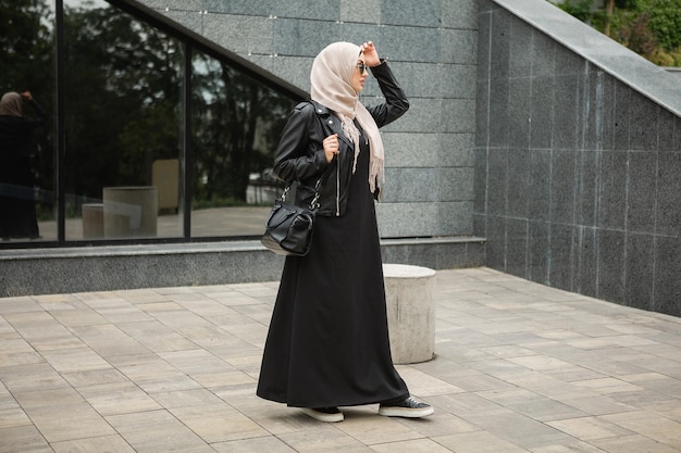 Mujer musulmana con estilo moderno en hijab en la calle de la ciudad