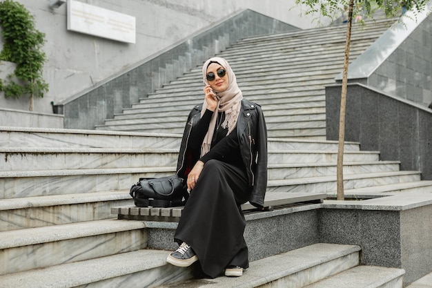 Mujer musulmana con estilo moderno en hijab en la calle de la ciudad