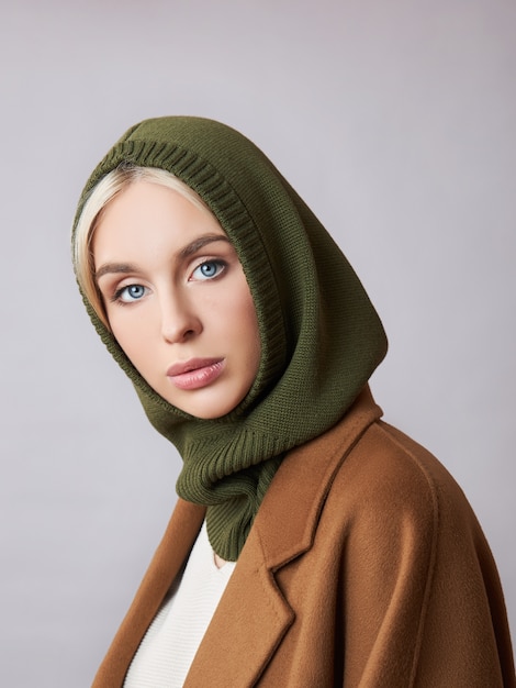 Mujer musulmana europea con un cabello rubio en una capucha de capó vestida en su cabeza. Hermosa chica con piel suave.