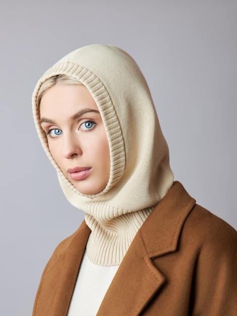 Mujer musulmana europea con un cabello rubio en una capucha de capó vestida en su cabeza.
