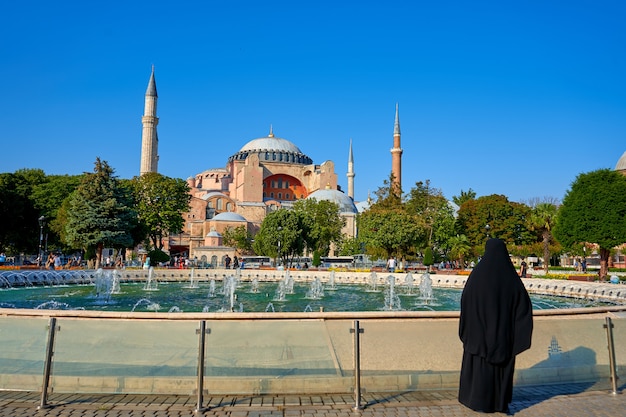 Foto una mujer musulmana con hijab mirando a la mezquita de sofía, en la plaza junto a la fuente