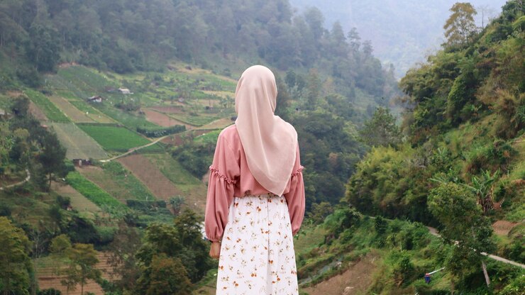 Mujer musulmana con hijab de pie mirando la belleza natural de las montañas de Indonesia