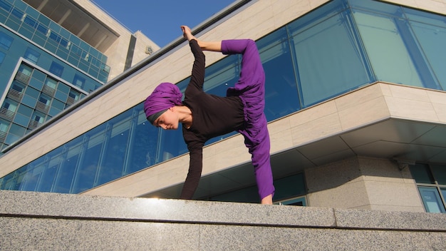 Mujer musulmana en hiyab en la ciudad haciendo ejercicio entrenamiento estiramiento de fuerza practicando estiramiento de esfuerzo