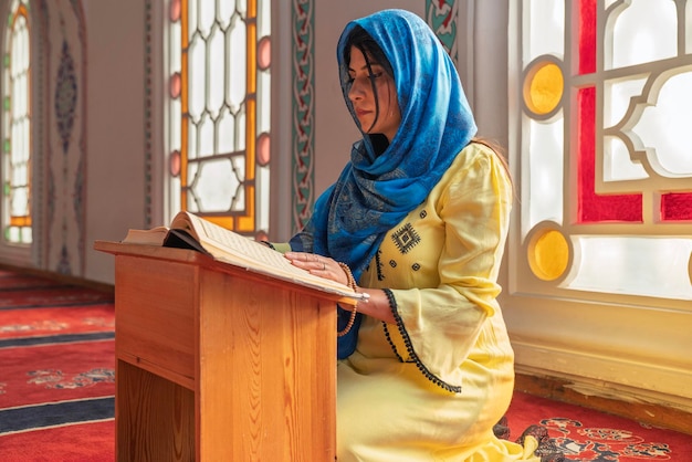 Mujer musulmana leyendo el Corán en la mezquita