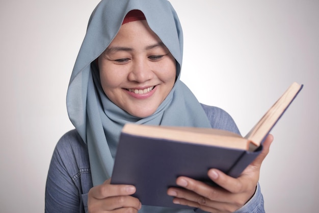 Mujer musulmana leyendo un libro sonriendo