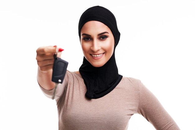 Mujer musulmana con las llaves del coche sobre blanco
