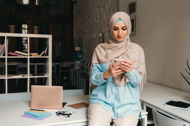 Mujer musulmana moderna en hijab en la sala de oficina