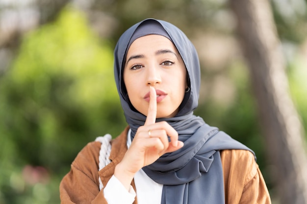 Mujer musulmana pidiendo silencio al aire libre Cerrar